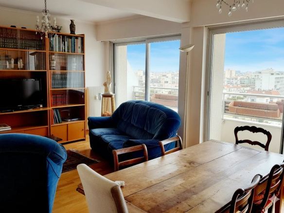Intérieur d'un duplex à Courbevoie avec vue sur la ville, salon et salle à manger.