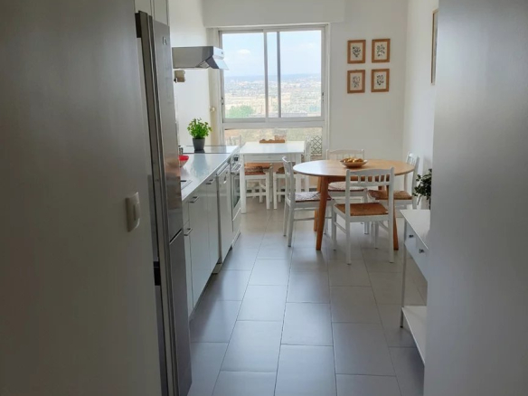 Intérieur d'un duplex à Courbevoie avec cuisine et salle à manger lumineuses.