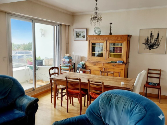 Intérieur d'un duplex à Courbevoie avec une salle à manger et un accès à un balcon.