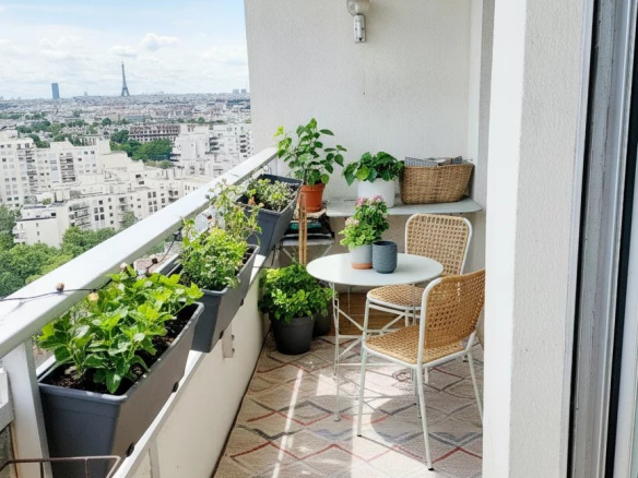 Balcon d'un duplex à Courbevoie avec vue sur Paris et la Tour Eiffel, décoré de plantes.