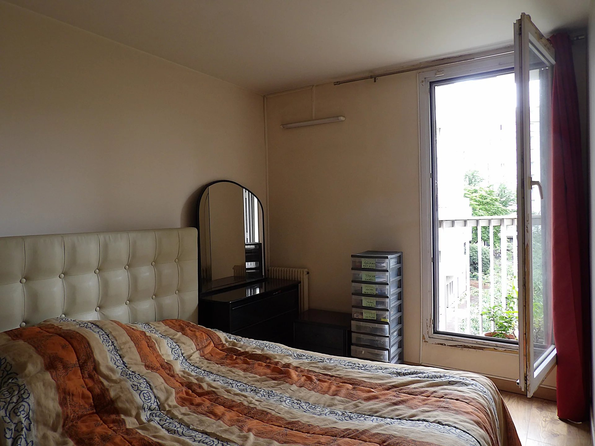 Chambre d’appartement à Paris 13ème Chambre d'un appartement à Paris 13ème avec un lit, un miroir et un balconnet.