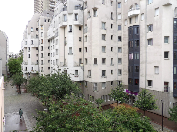Vue d'un grand appartement dans le 13ème arrondissement de Paris, avec balcons et espaces verts.