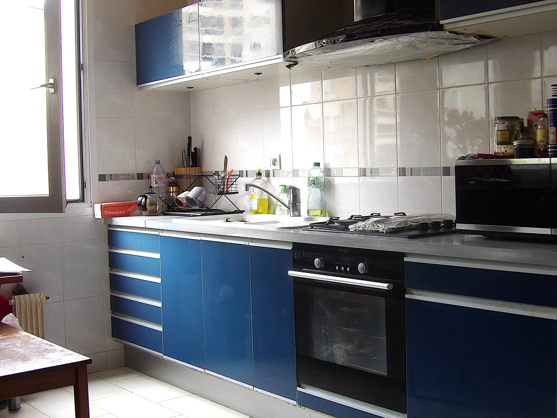Cuisine d’un appartement à Paris 13ème Cuisine d'un grand appartement à Paris 13ème avec des meubles bleus et des équipements modernes.
