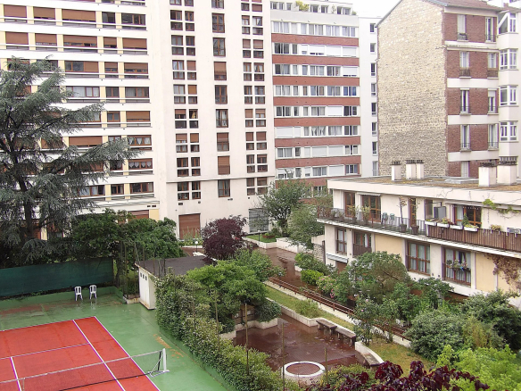Vue d'un espace extérieur avec courts de tennis et jardins dans un immeuble résidentiel à Paris 13ème.