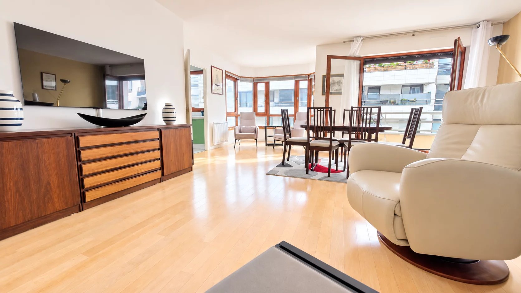 Appartement lumineux à Boulogne-Billancourt Intérieur d'un appartement lumineux avec de nombreuses fenêtres et un balcon à Boulogne-Billancourt.