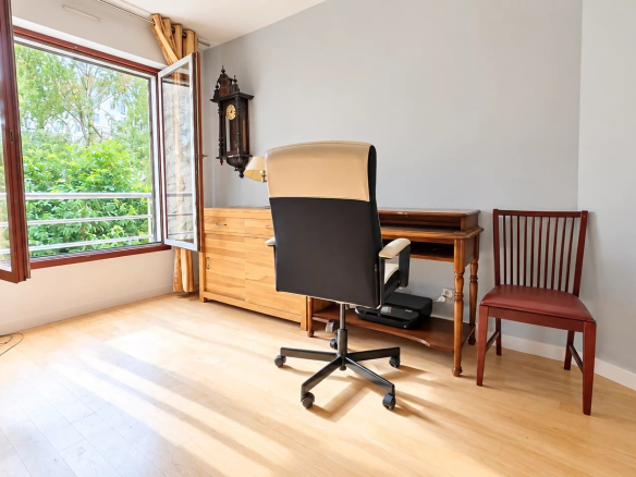 Intérieur d'un appartement à Boulogne-Billancourt avec bureau, fenêtre ouverte et lumière naturelle.