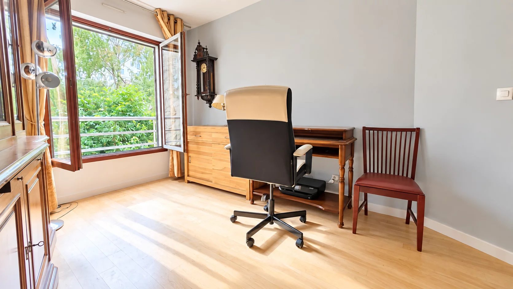 Appartement à Boulogne-Billancourt Intérieur d'un appartement à Boulogne-Billancourt avec bureau, fenêtre ouverte et lumière naturelle.