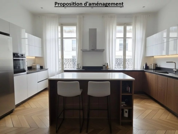 Cuisine moderne avec îlot central et grandes fenêtres dans un appartement à Paris 17ème.