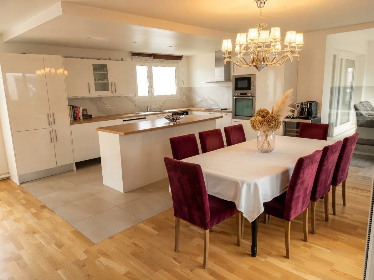 Intérieur d’un appartement à Courbevoie Intérieur d'un appartement moderne avec cuisine ouverte et salle à manger, table pour huit personnes.
