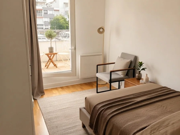 Chambre d'appartement à Courbevoie avec lit, fauteuil et accès à une terrasse.