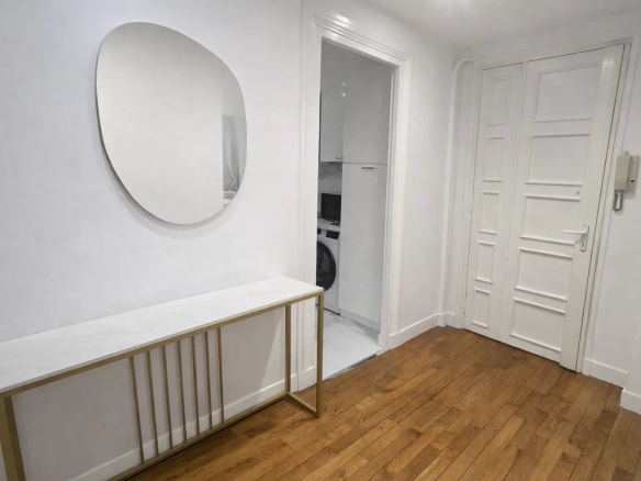 Entrance to a bright apartment with a mirror and a wooden cabinet
