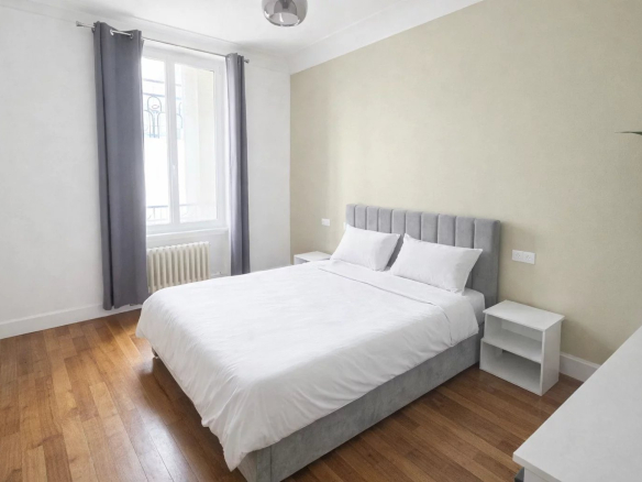 Room in an apartment in Levallois-Perret with a double bed and bright windows.