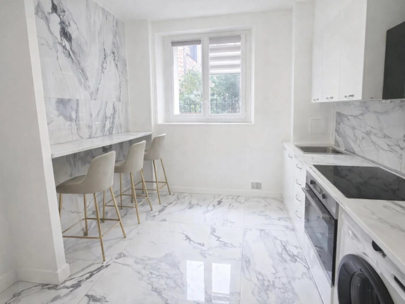 Modern and bright kitchen in an apartment in Levallois-Perret with bar and marble furniture.