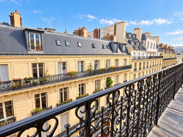 Vue depuis un balcon d'un duplex à Paris 17ème, avec immeubles haussmanniens en arrière-plan.