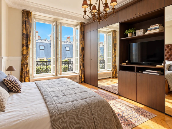 Chambre d'un duplex à Paris 17ème avec fenêtres ouvertes et vue sur le ciel.