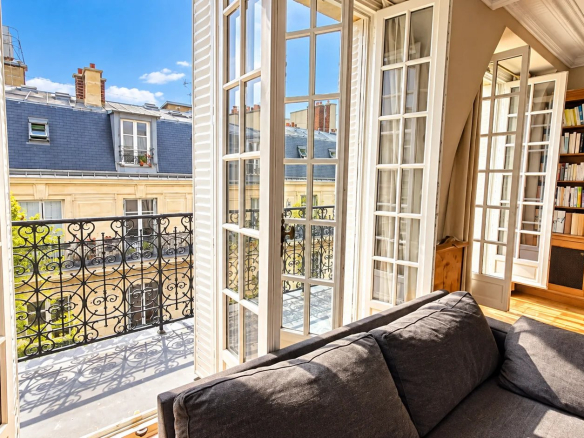 Intérieur d'un duplex à Paris 17ème avec fenêtres ouvertes et vue sur balcons.