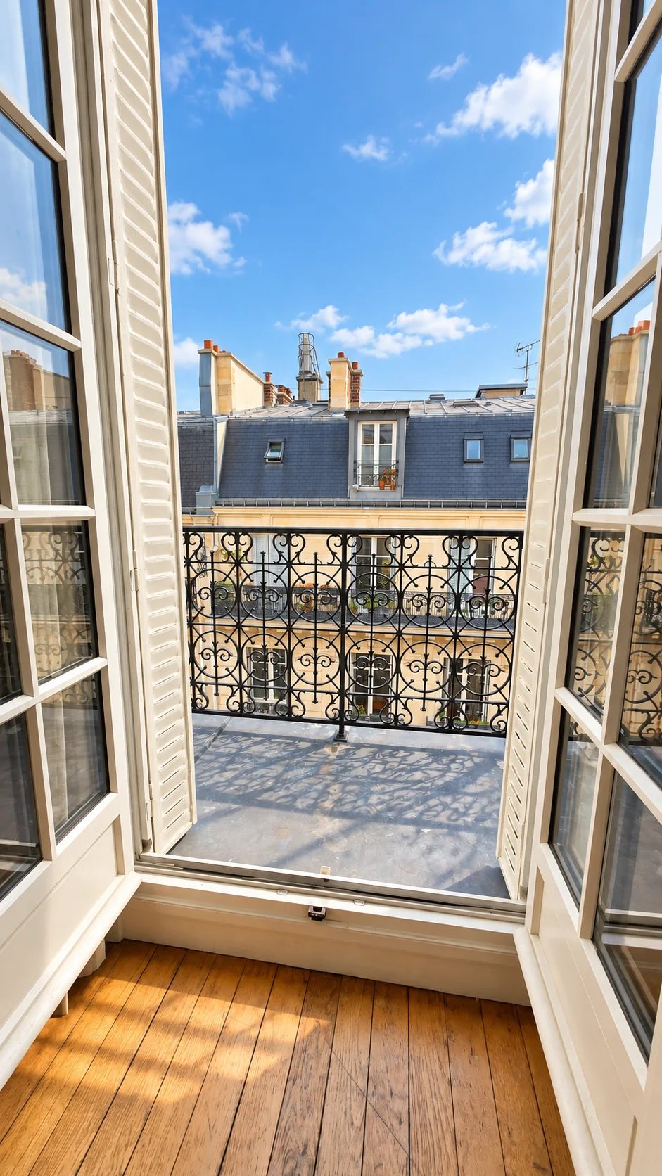 Balcon d’un duplex à Paris 17ème Vue depuis un balcon d'un duplex à Paris 17ème, ciel bleu et balustrade en fer forgé.