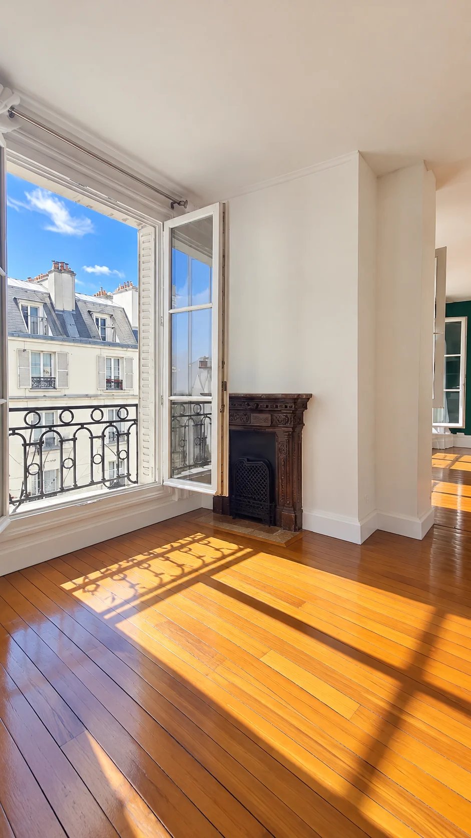 Bright apartment in the 16th arrondissement of Paris Interior of a bright apartment with parquet flooring and windows open to the blue sky.
