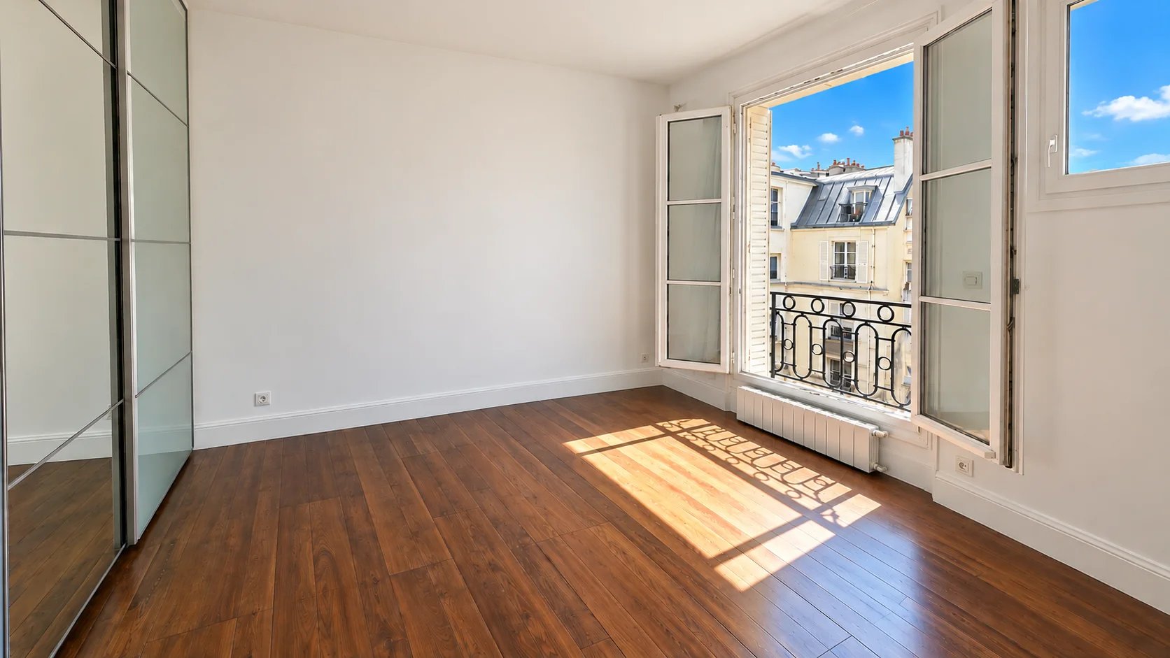 Room in Paris 16th Bright room with windows in Paris 16th arrondissement, parquet flooring and white walls.