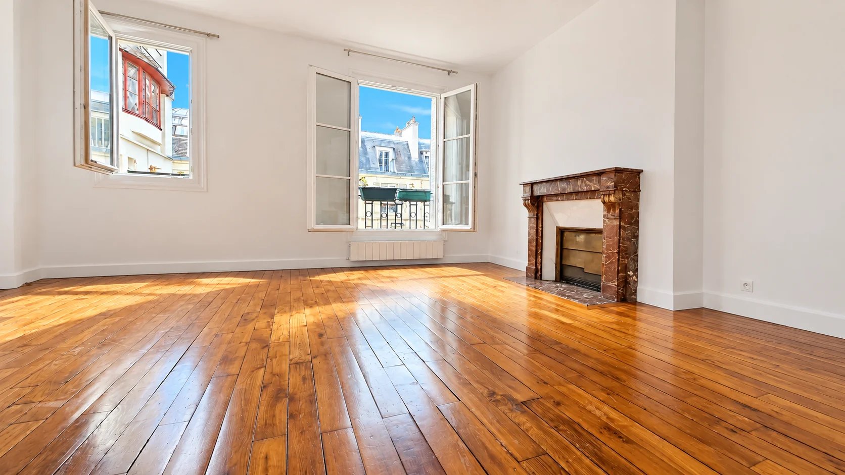 Bright apartment in the 16th arrondissement of Paris Interior of a bright apartment with wooden parquet flooring and open windows, Paris 16th arrondissement.