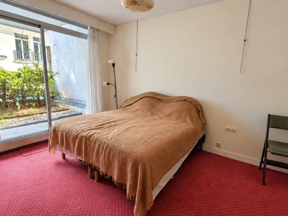 Room in an apartment in the 16th arrondissement of Paris with a bed and access to a private garden.