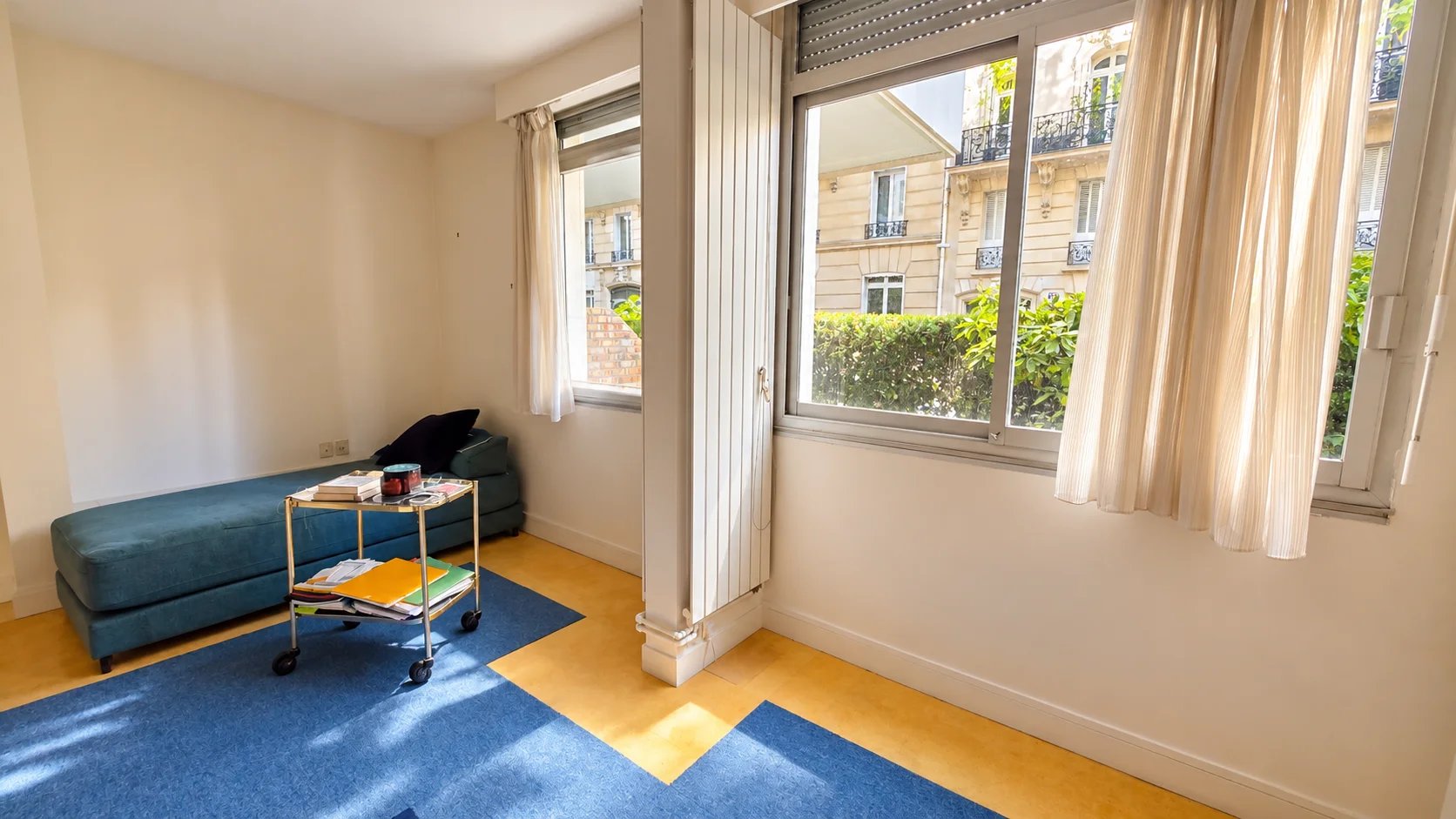 Family apartment in the 16th arrondissement of Paris Interior of an apartment in the 16th arrondissement of Paris with a living area and windows overlooking the outside.