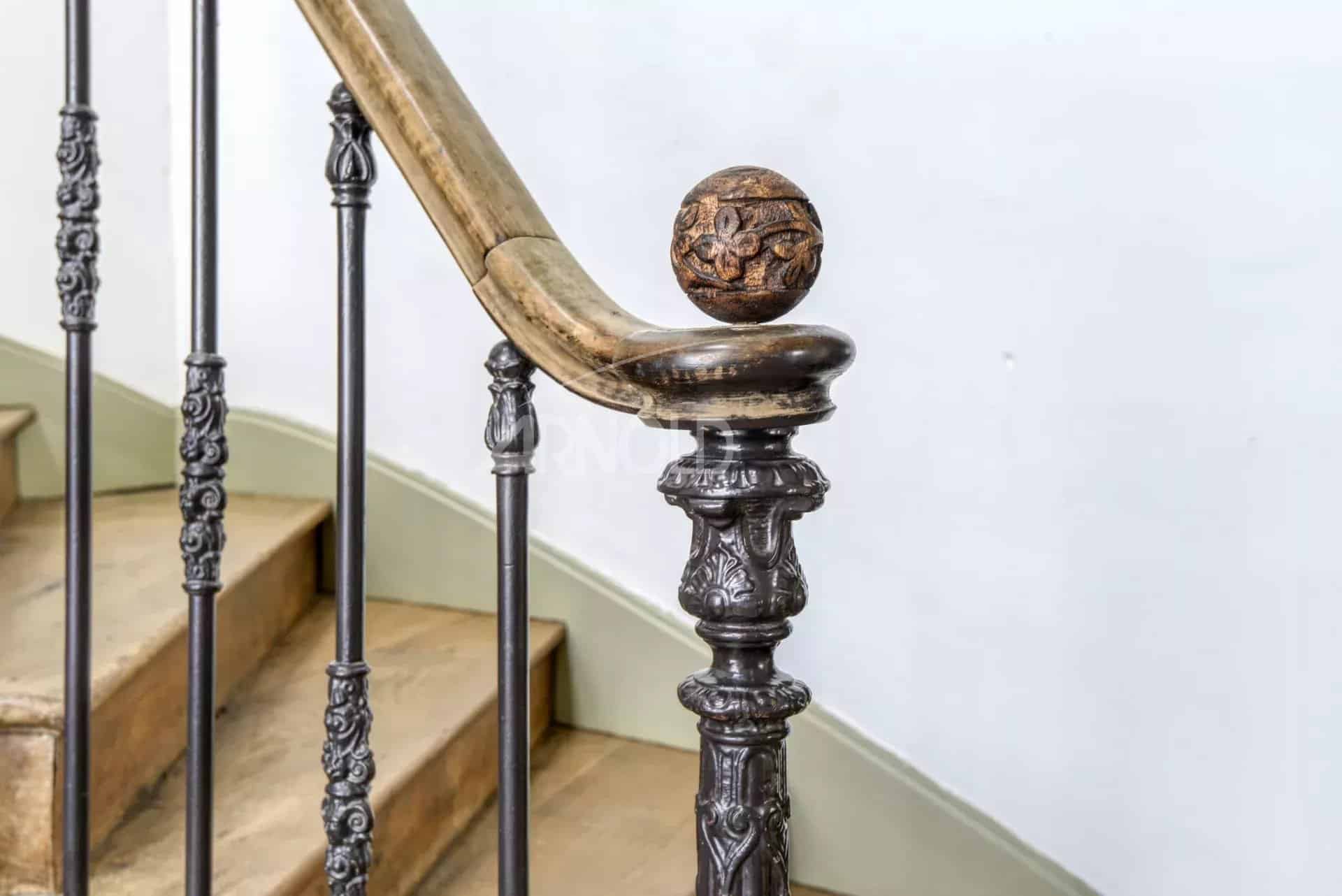 Wrought iron stair railing with wooden balusters in a private mansion in Ancenis