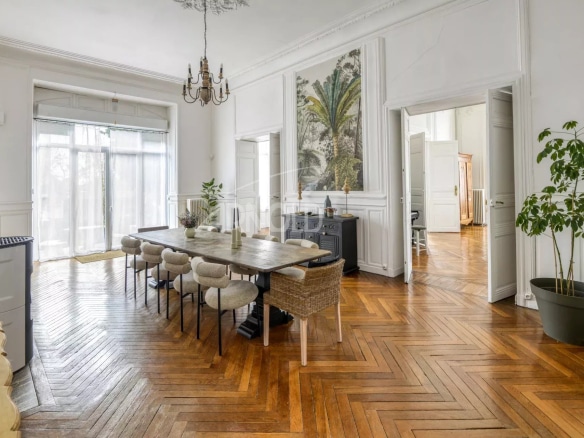 Interior of a renovated private mansion with a large dining table and wooden parquet flooring in Ancenis-Saint-Géréon.