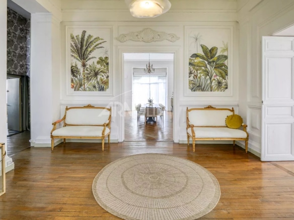 Interior of a private mansion with walls decorated with plants and a wooden floor.