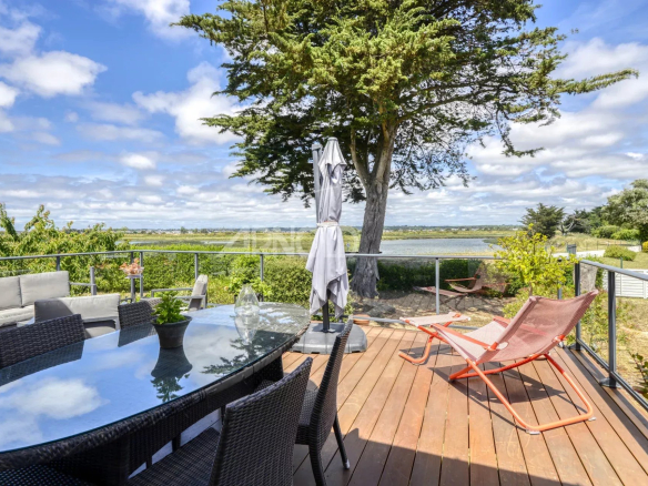 Terrace with garden furniture and views of the tidal creek and nature in Pouliguen.