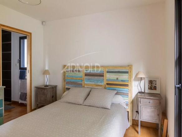 Bedroom in a contemporary house with a double bed and colorful wood decor.