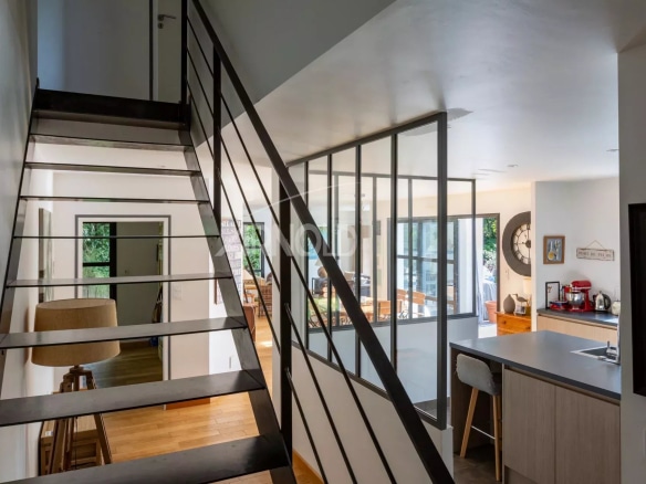 Interior of a contemporary house with staircase and open kitchen/living room.