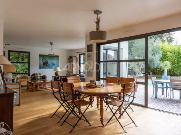 Interior of a contemporary house with dining room and garden view.