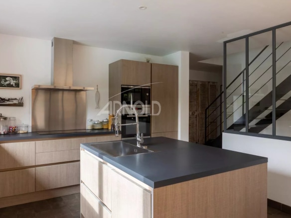 Modern kitchen in a contemporary house with central island and wooden elements.