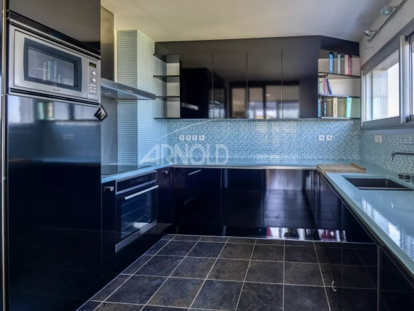 Modern and elegant kitchen in a prestigious duplex in Nantes, with black furniture and blue tiles.
