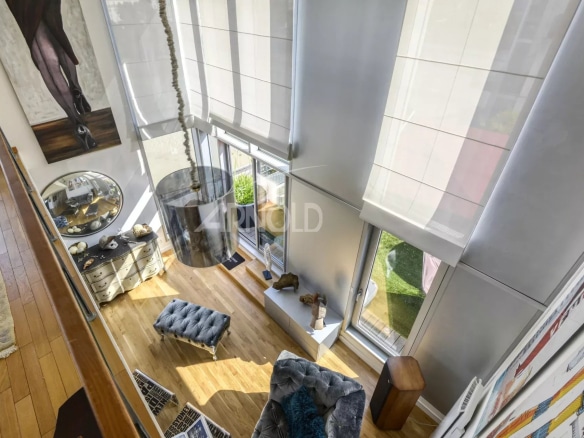 Interior of a prestigious duplex with large bay windows and elegant furniture.