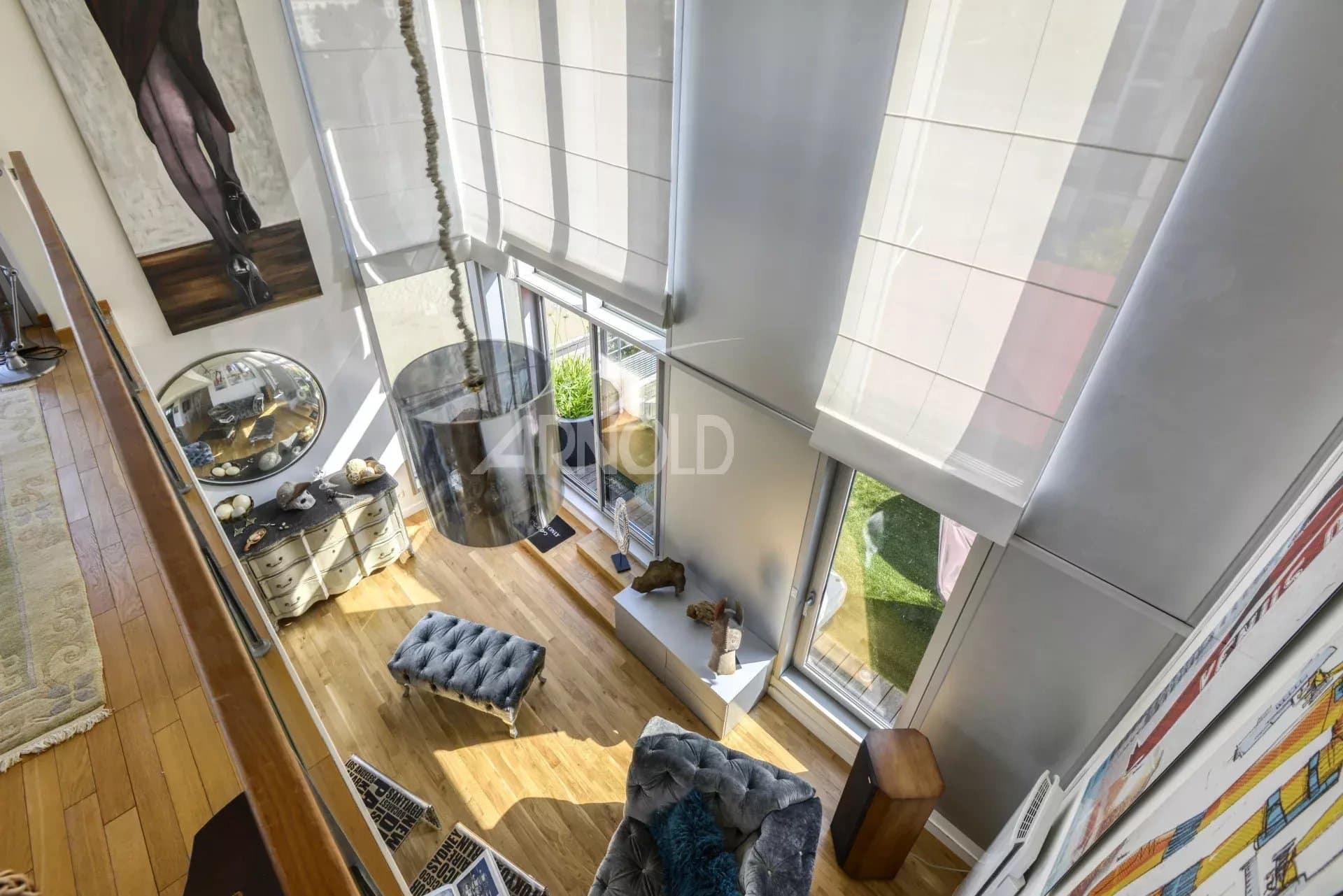 Interior of a prestigious duplex with large bay windows and elegant furniture.