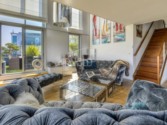Interior of a prestigious duplex with a bright living room and bay windows, overlooking the Loire in Nantes.