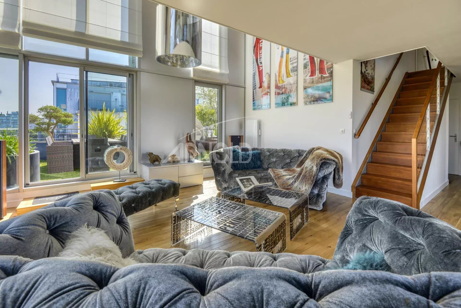 Interior of a prestigious duplex with a bright living room and bay windows, overlooking the Loire in Nantes.