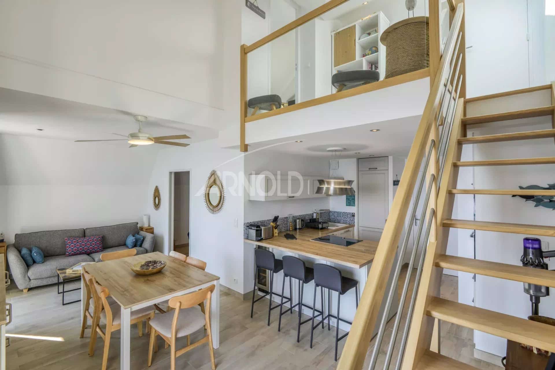 Intérieur d'un appartement en duplex à Batz-sur-Mer avec vue sur la mer, salon et cuisine moderne.