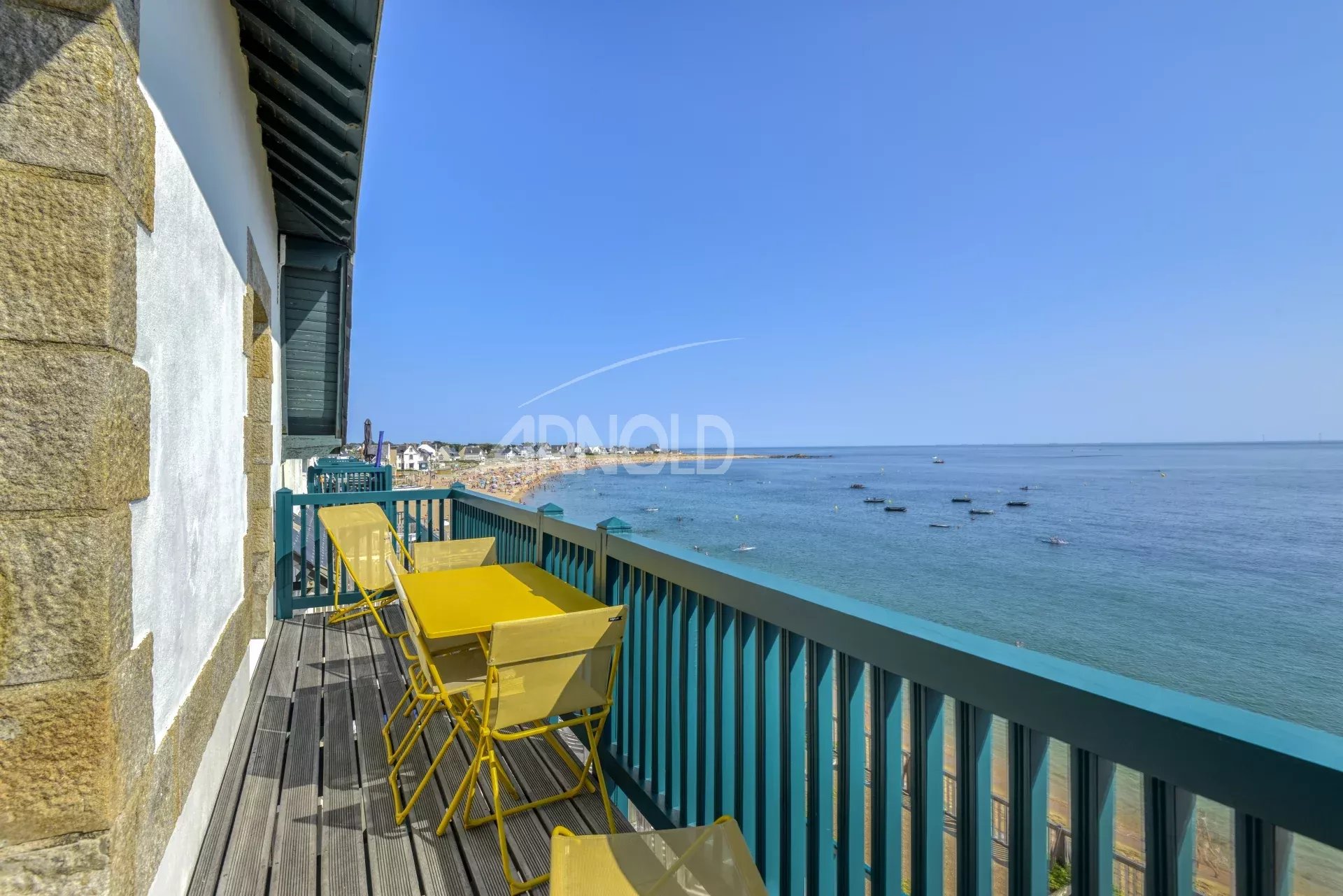 Terrasse d'un appartement avec vue sur l'océan à Batz-sur-Mer, chaises jaunes sur le balcon.