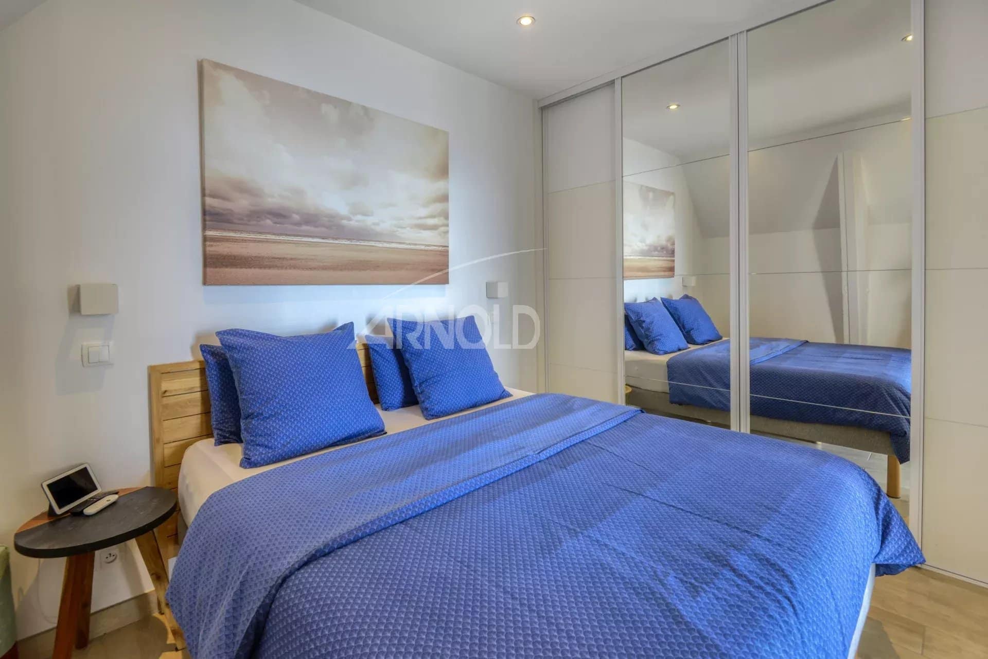 Chambre d'appartement rénové avec lit double et décor bleu à Batz-sur-Mer.