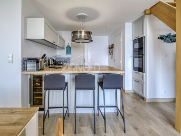 Intérieur d'un appartement moderne avec cuisine ouverte et bar, Batz-sur-Mer.