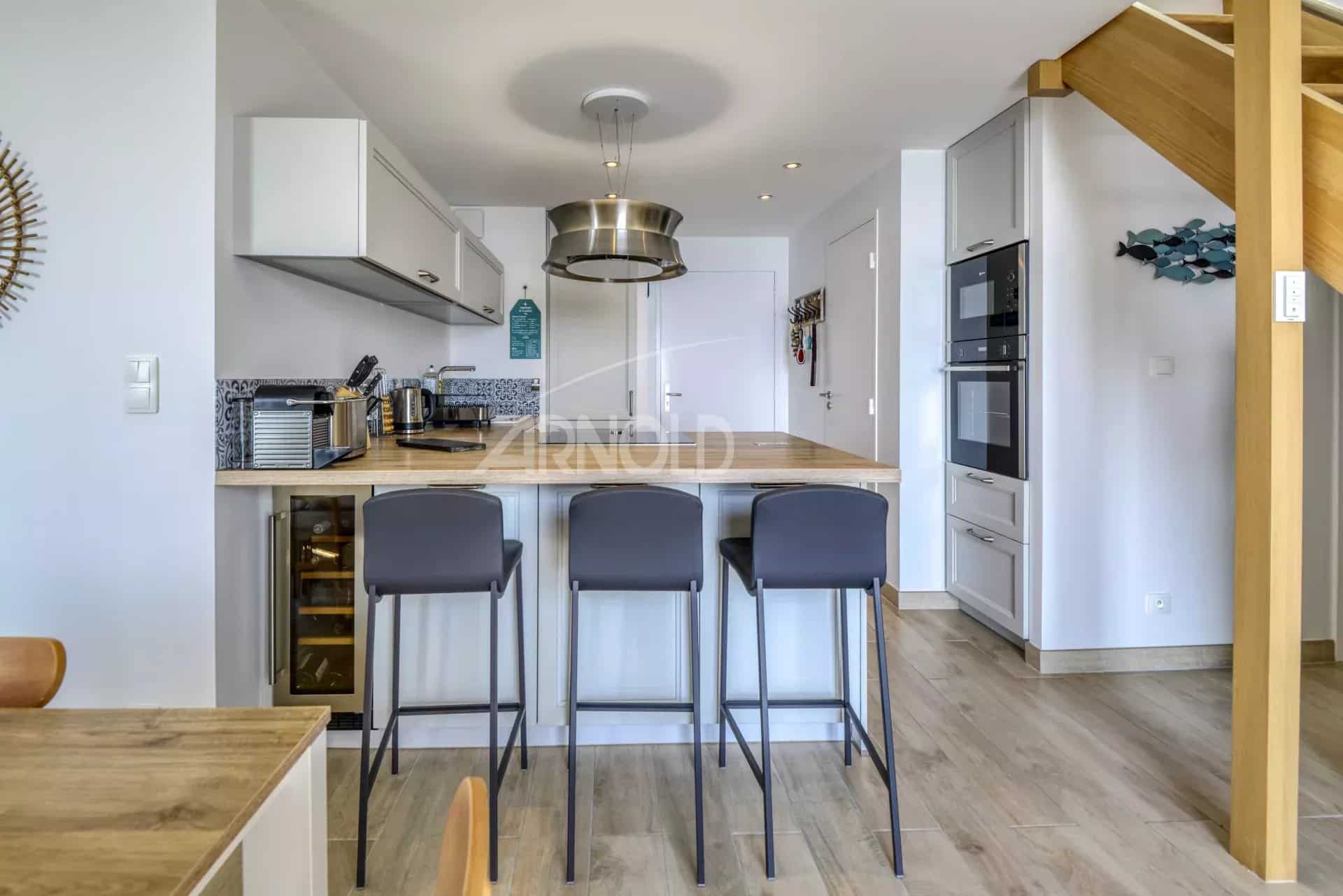 Intérieur d'un appartement moderne avec cuisine ouverte et bar, Batz-sur-Mer.