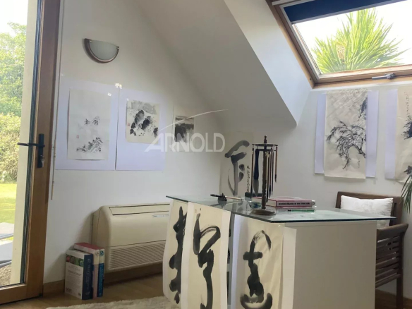 Interior of a house with a bright office and artwork hanging on the wall.