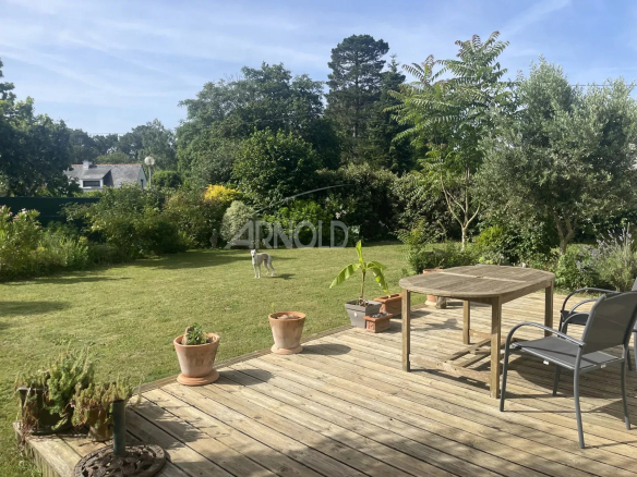 Wooden terrace with green garden and dog, family home in Vannes.