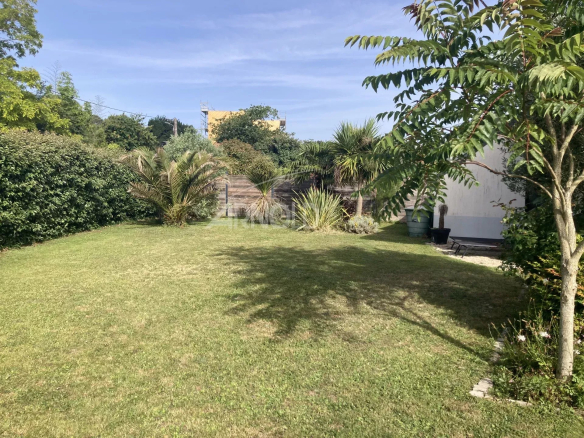 Garden of a family home in Vannes with lawn and vegetation.