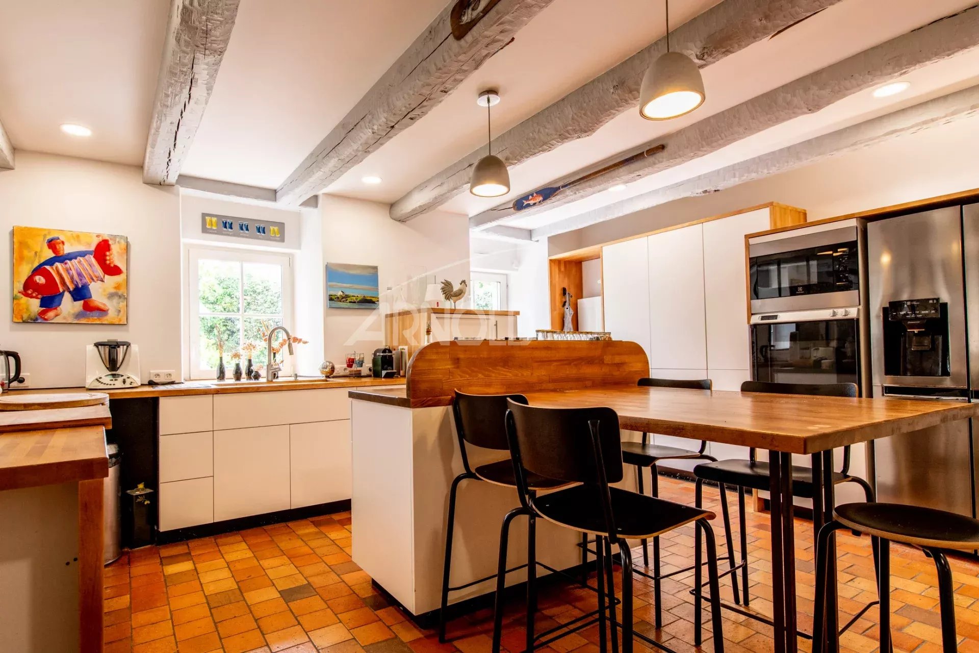 Kitchen of a stone farmhouse in Baden Modern kitchen with central island and integrated appliances in a stone farmhouse.