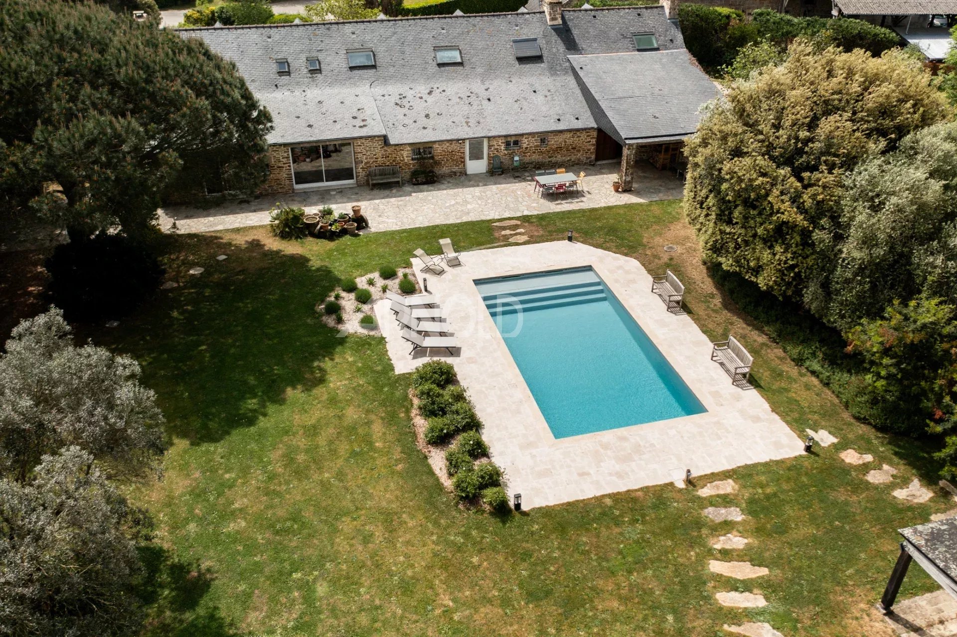 Stone farmhouse with swimming pool in Baden Aerial view of a stone farmhouse with swimming pool and wooded garden in Baden.