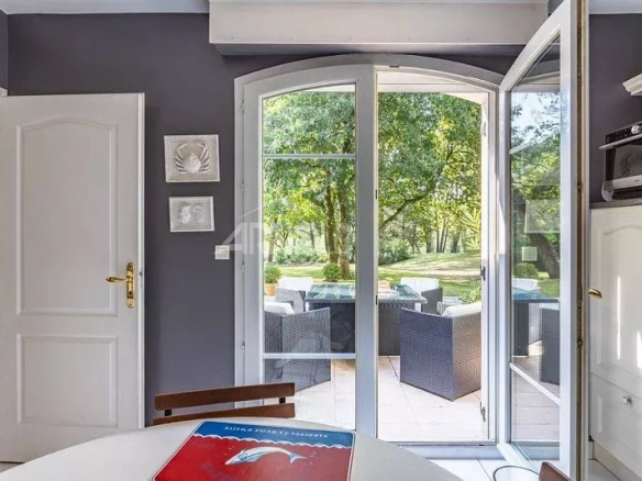 Intérieur d'une maison à Vannes avec portes-fenêtres donnant sur un jardin verdoyant.